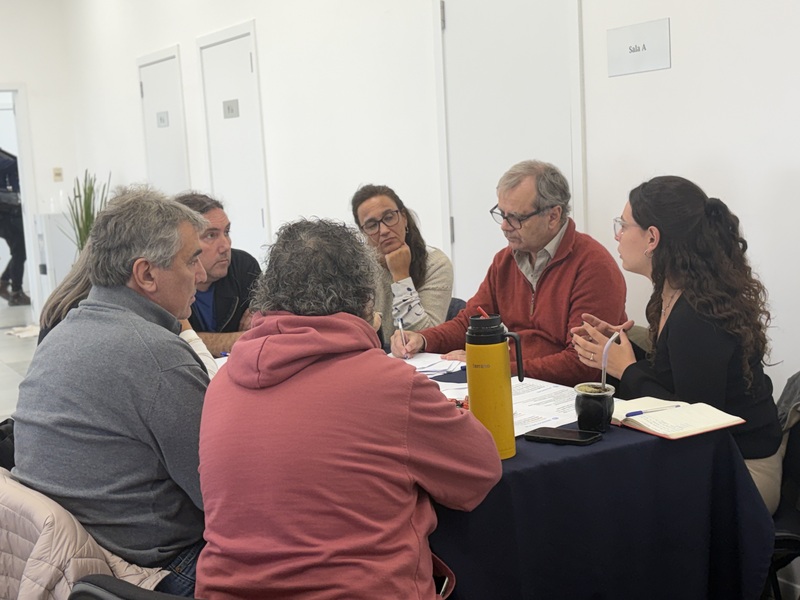 Participantes alrededor de una mesa con papeles