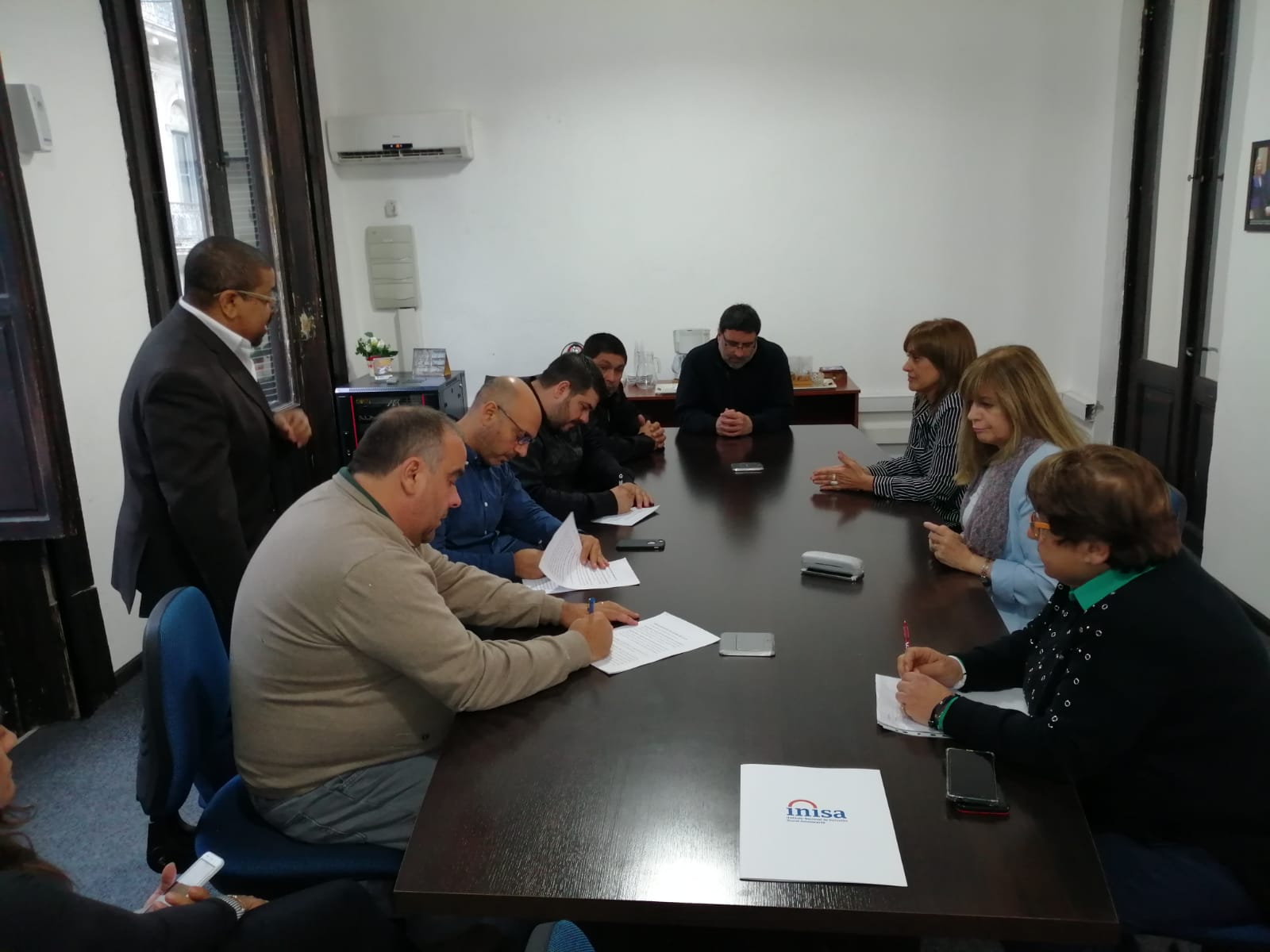 Foto de reunión de directivos firmando acuerdos