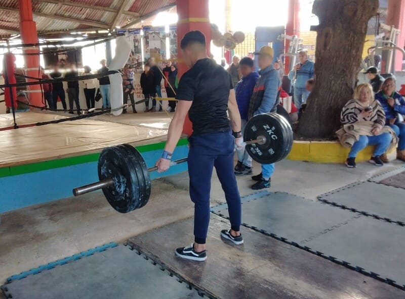 Joven levantando pesas en el gimnasio