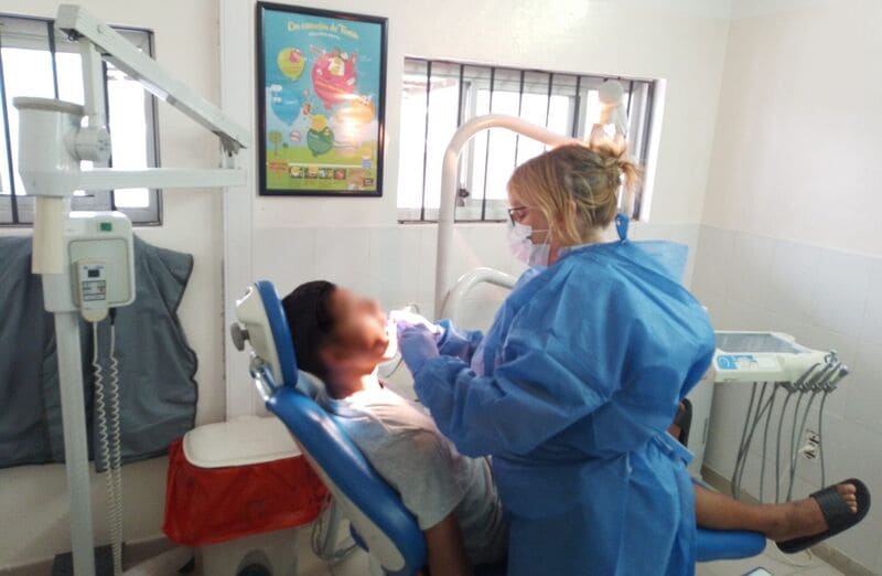 Odontóloga atendiendo a un joven