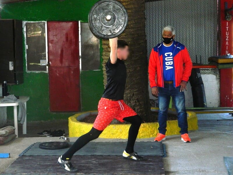 Profesor Barcelán con joven levantando pesas